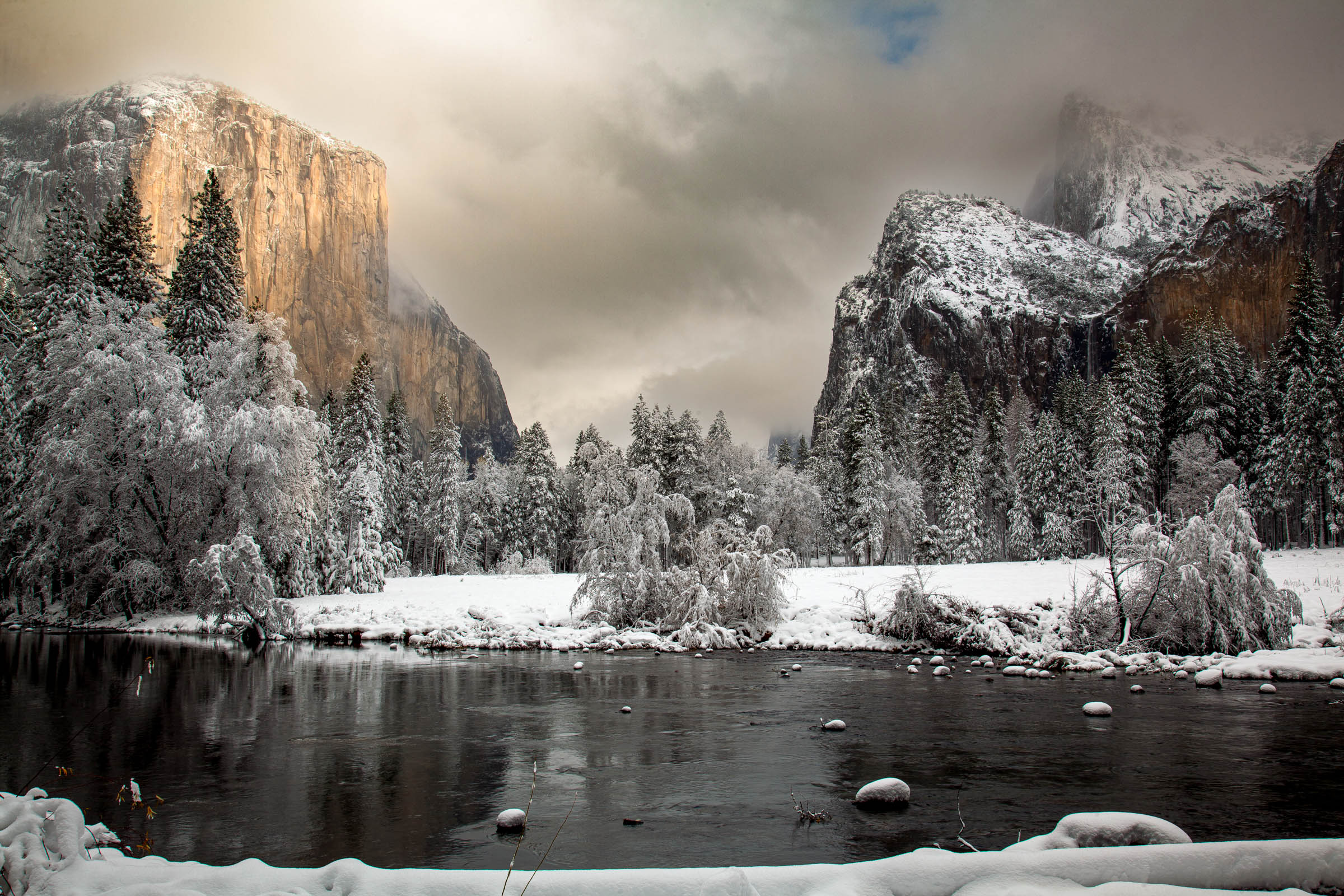 Yosemite Valley in winter — El Capitan lit gold at dawn above the snow-lined Merced